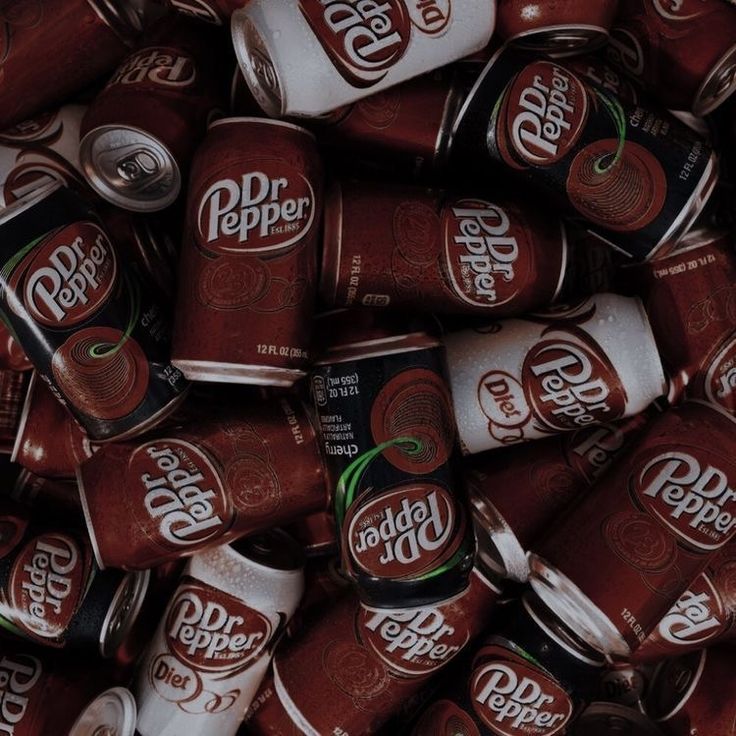 a pile of dr pepper soda cans sitting on top of each other