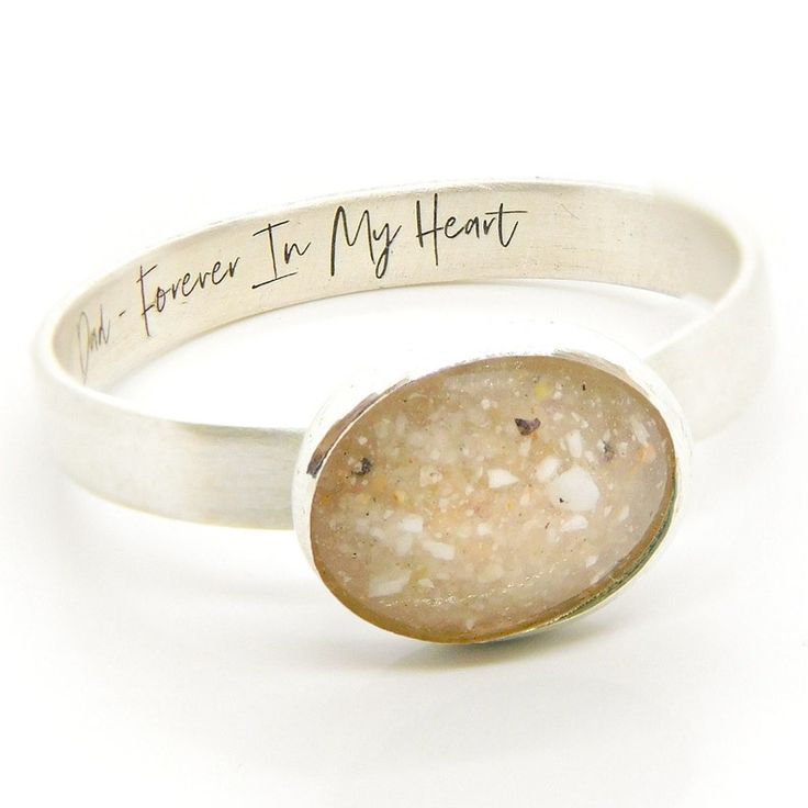 a close up of a ring with a stone on the bottom and writing on it