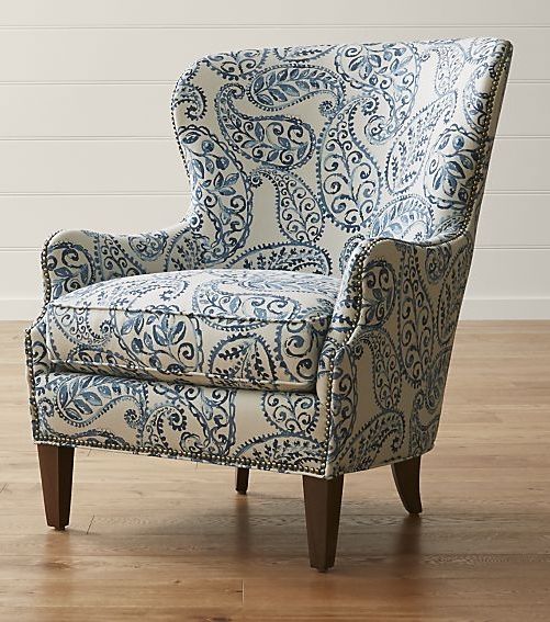 a blue and white patterned chair sitting on top of a hard wood floor