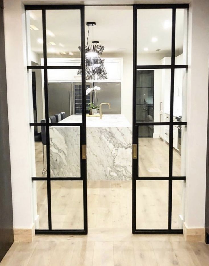 an open door leading to a kitchen with marble counter tops and cabinets in the background