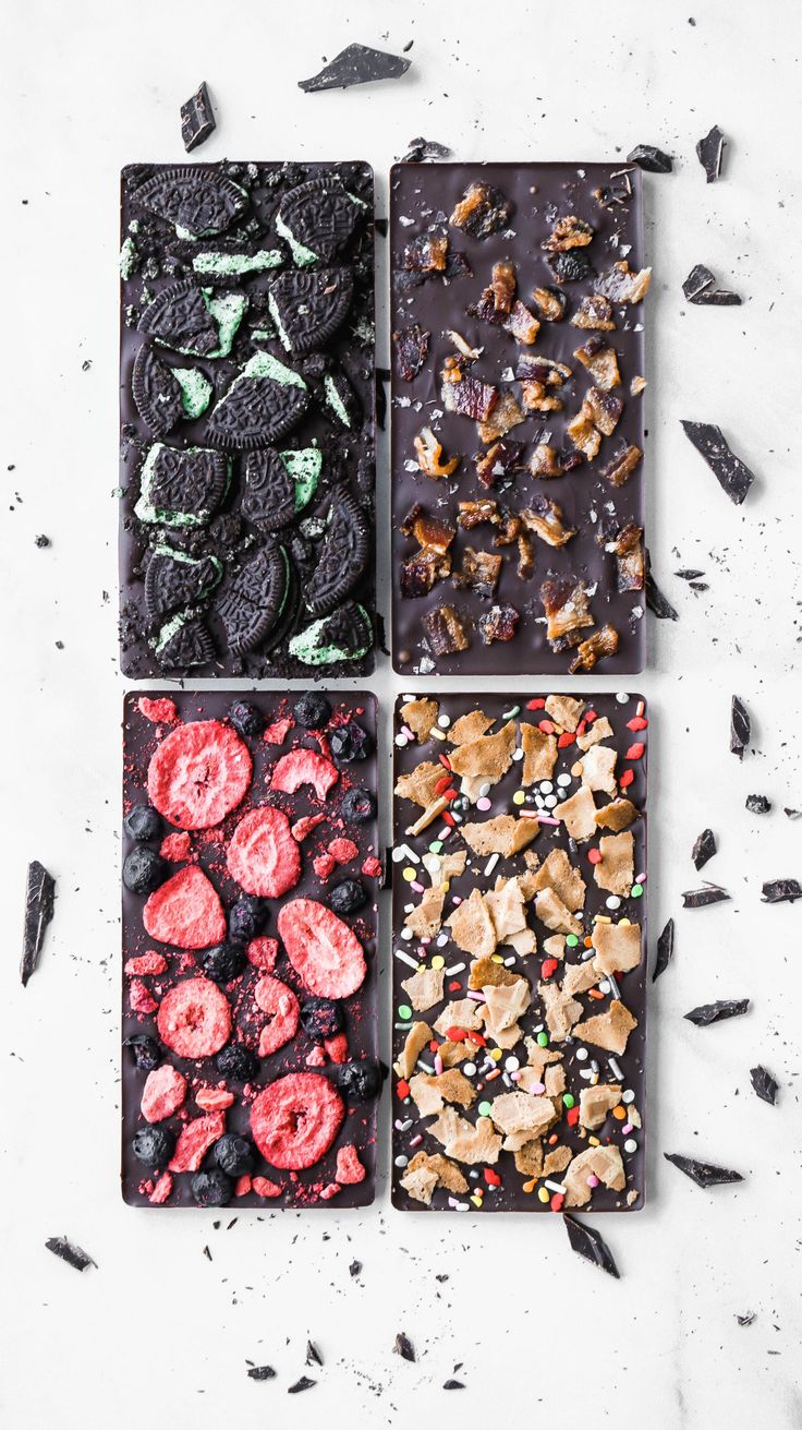 four different types of desserts in trays on a white surface with black and red sprinkles