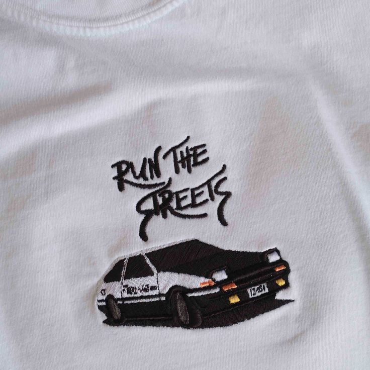 From our 'Run the Streets' collection this AE86 embroidery on a pigment tee for a vintage look. Made from fairly grown US cotton, these t-shirts are 6.1 oz, 100% ring-spun cotton.• 4" embroidered graphic.• Soft ring-spun cotton fabric.• Relaxed fit.• Free shipping, ships in poly-bag (more options at checkout). Vintage Embroidered Shirt, Tshirt Design Embroidery, Car Clothing Design, Embroided T Shirts, Clothe Designs, Clothes Embroidery, Clothes Embroidery Diy, Car Apparel, Merch Ideas