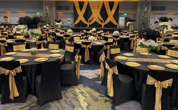 tables with black and gold linens are set up for an event