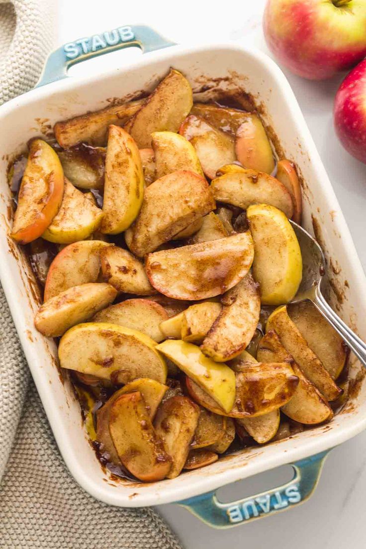 baked apples in a baking dish with caramel sauce