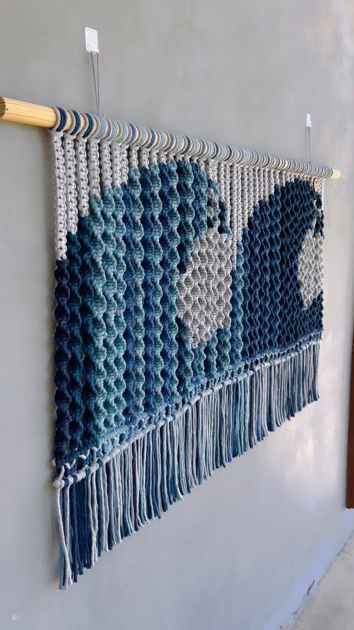 a blue and white wall hanging on the side of a building