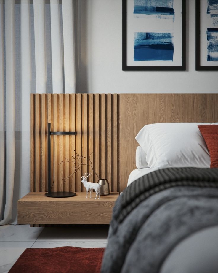 a bed room with a neatly made bed and two pictures on the wall above it