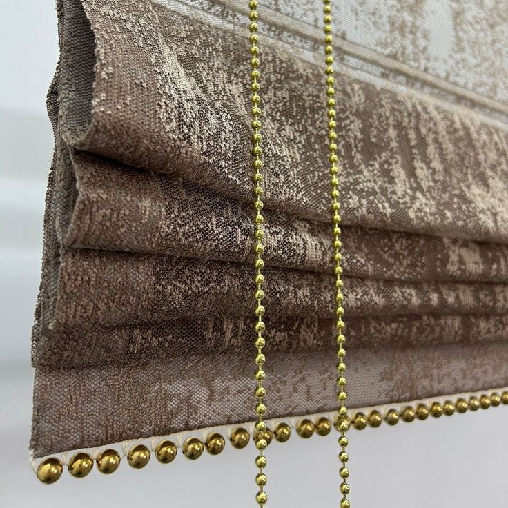 gold beaded curtains hanging from the side of a window with beads attached to them