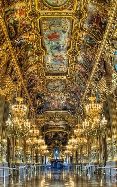 an ornately decorated hall with chandeliers and paintings on the ceiling