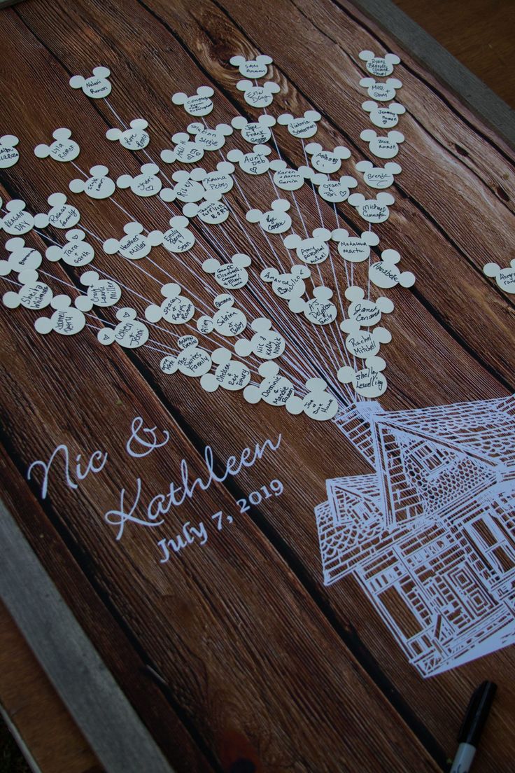 a wooden table topped with lots of white paper cut outs and flowers on top of it