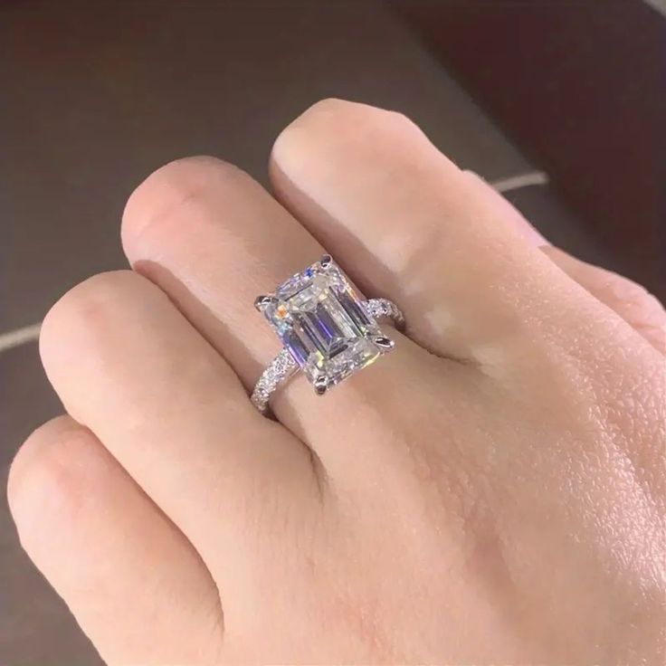 a woman's hand holding an engagement ring