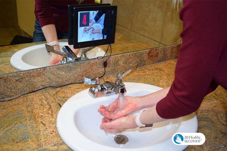 a woman is washing her hands in the bathroom sink