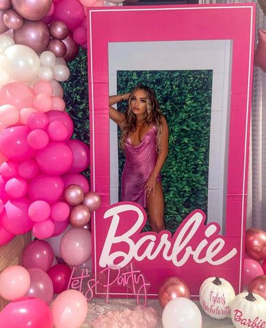 a pink and white photo frame surrounded by balloons