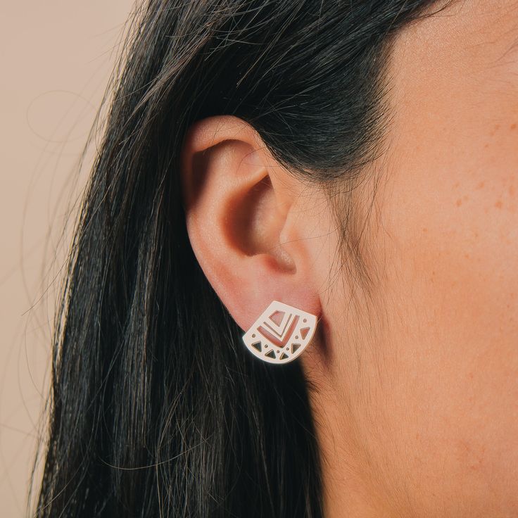 Introducing the Myra Stud Earrings! These pretty little sterling silver earrings are perfect for adding a touch of bohemian chic to any look. They feature a geometric triangle design with aztec-inspired cut outs in the center. The simple silver stud design makes them easy to wear with anything, and they look great alone or teamed with other studs for a stacked look. Whether you're dressing up or dressing down, these earrings are sure to add a touch of style. So go ahead and show your unique sens Stud Design, Triangle Design, Geometric Triangle, Bohemian Chic, Silver Studs, Cut Outs, Sterling Silver Earrings, Ear Cuff, Silver Earrings