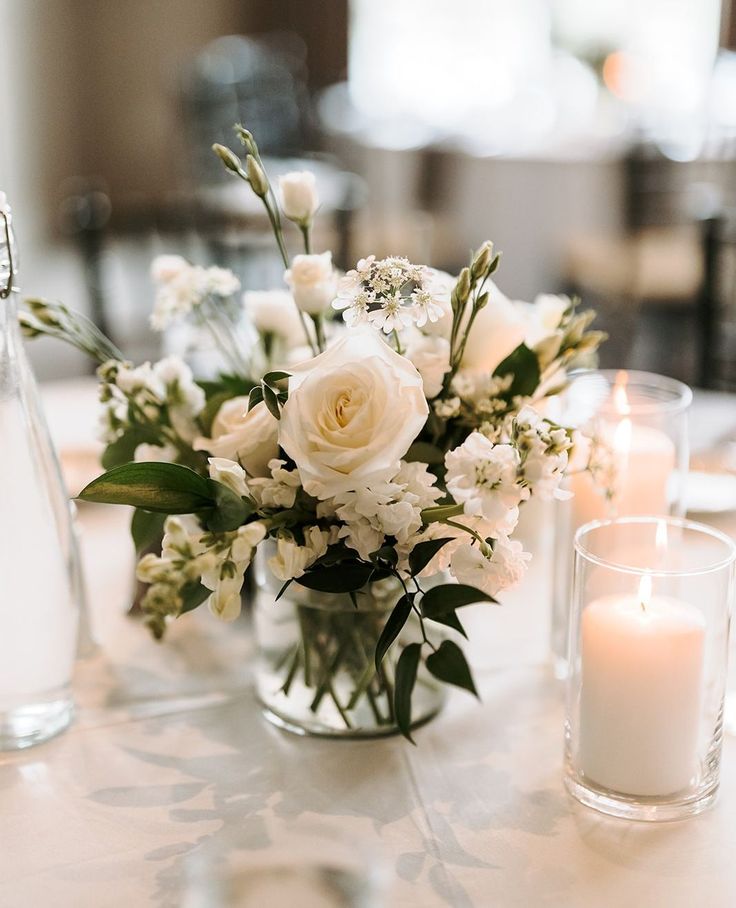 Sweet and petite wedding centerpiece

Vase centerpiece with white roses, white lisianthus, white larkspur, ruscus greens, votive candles
⁠ Wedding Centerpieces Low Flowers, White Centerpiece Wedding Simple, Simple Wedding Table Centerpieces Votive Candles, Simple White Centerpieces Flower, Wedding Flowers White And Green Centerpieces, Small Table Centrepiece, White Flower Centrepiece Wedding, Bud Flowers Wedding Table, Minimal Flower Centerpieces