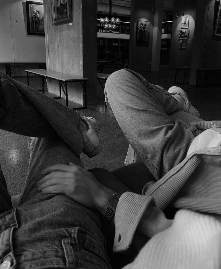 black and white photograph of two people laying on the floor with their feet propped up