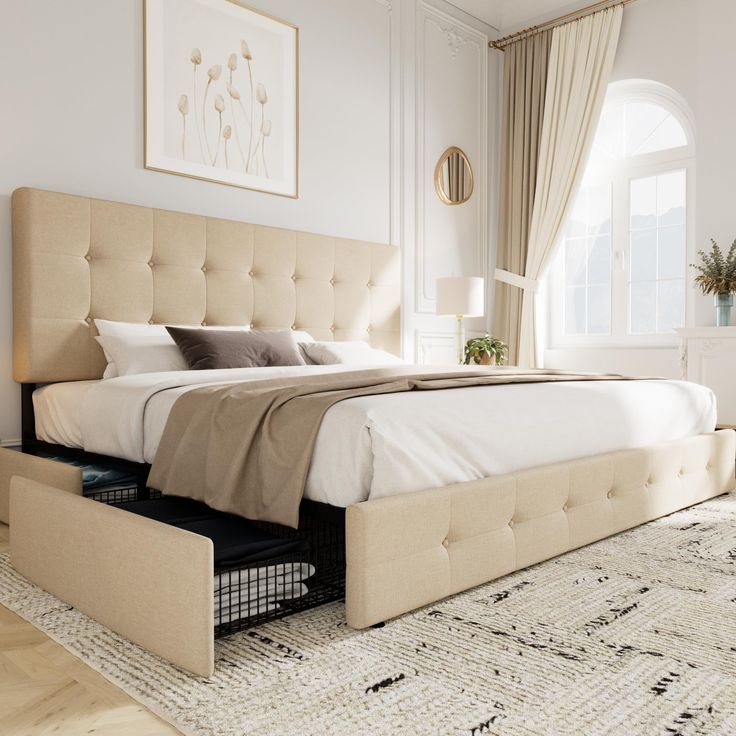 a large bed sitting on top of a wooden floor next to a white dresser and window