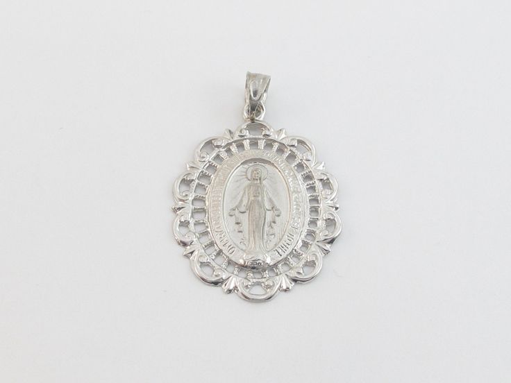 "fabulous 14k solid White Gold Virgin Mary Charm Pendant! * Material: 14k gold, Not plated or filled * Pendant Length: 1\" or 27 mm long not including the bail * Pendant Width: 7/8\" or 22 mm wide * Weight: 3.80 grams * Complementary Gift Box There is a prayer around Mary which says: O Mary conceived without sin pray for us who have recourse to thee. This Pendant is the same size as a quarter. Images may be enlarged to show detail and the item may look larger than it appears in person.In order t Anniversary Miraculous Medal Round Pendant Jewelry, Elegant Silver Jewelry For Commemoration, White Gold Miraculous Medal Round Pendant, White Gold Miraculous Medal Jewelry In Sterling Silver, Elegant Round Miraculous Medal Jewelry, Elegant Miraculous Medal Jewelry, Oval Miraculous Medal Jewelry For Anniversary, Silver 14k Stamped Necklace For Commemoration, Silver 14k Stamped Necklaces For Commemoration