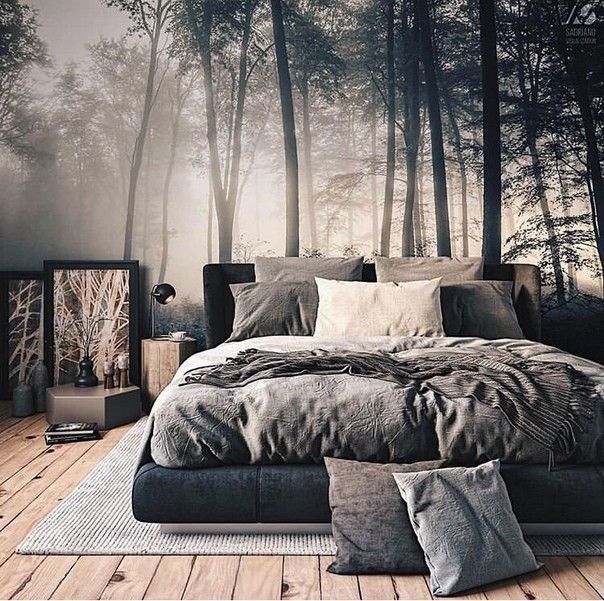 a large bed sitting in a bedroom next to a forest wall mural