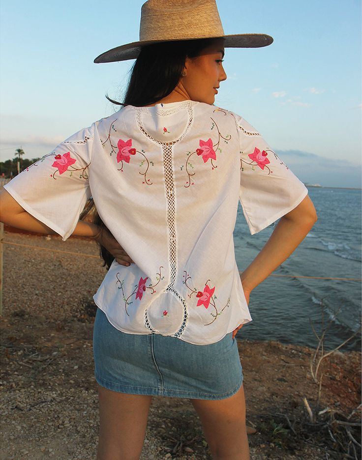 Tie front blouse in white with hand embroidered floral details and crochet panels. V neckline. Short sleeve. Ties to front. Size M, EU 38-42 / UK 10-14. Measurements: 40"/ 102cm bust - 12" / 30cm sleeve length - 25" / 64cm blouse length. Condition - New. Material - Cotton. Sustainability - Remade by our in house team using vintage fabrics. Model is a UK 6/8 & 5'7" tall. Embroidered V-neck Top For Day Out, Summer V-neck Blouse With Embroidered Hem, Spring Boho Collar Short Sleeve Tops, Spring Beach Tops With Boho Collar, Spring Beach Top With Boho Collar, Spring Short Sleeve Blouse With Boho Collar, Floral Embroidered Short Sleeve Top For Day Out, Summer Blouse With Embroidered Neckline, Day Out Floral Embroidered Short Sleeve Top