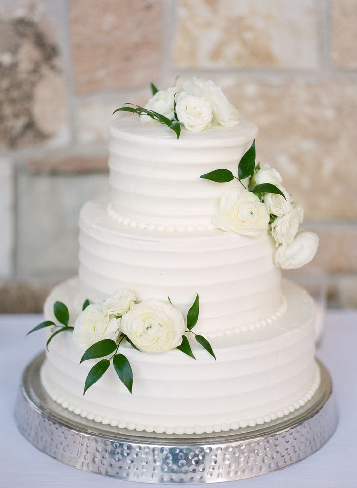 a white wedding cake with flowers on top