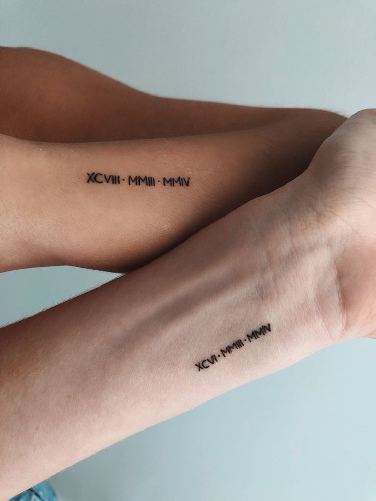 two people with matching tattoos on their arms, one has the words xcwm and the other is not