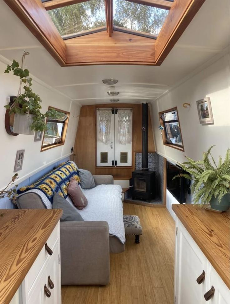 the interior of a tiny home with wood flooring and skylights on the ceiling