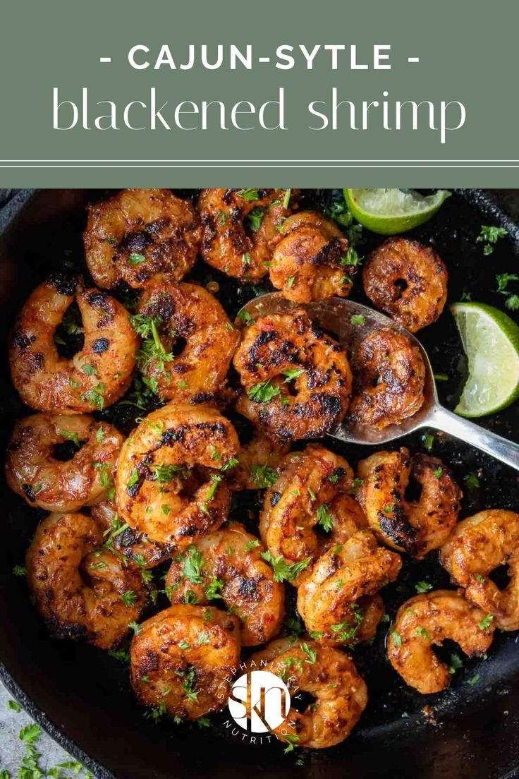 shrimp in a skillet with lime wedges and garnish on the side