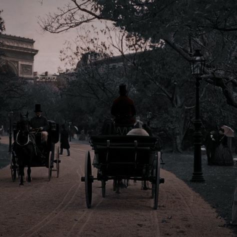 two horse drawn carriages traveling down a street