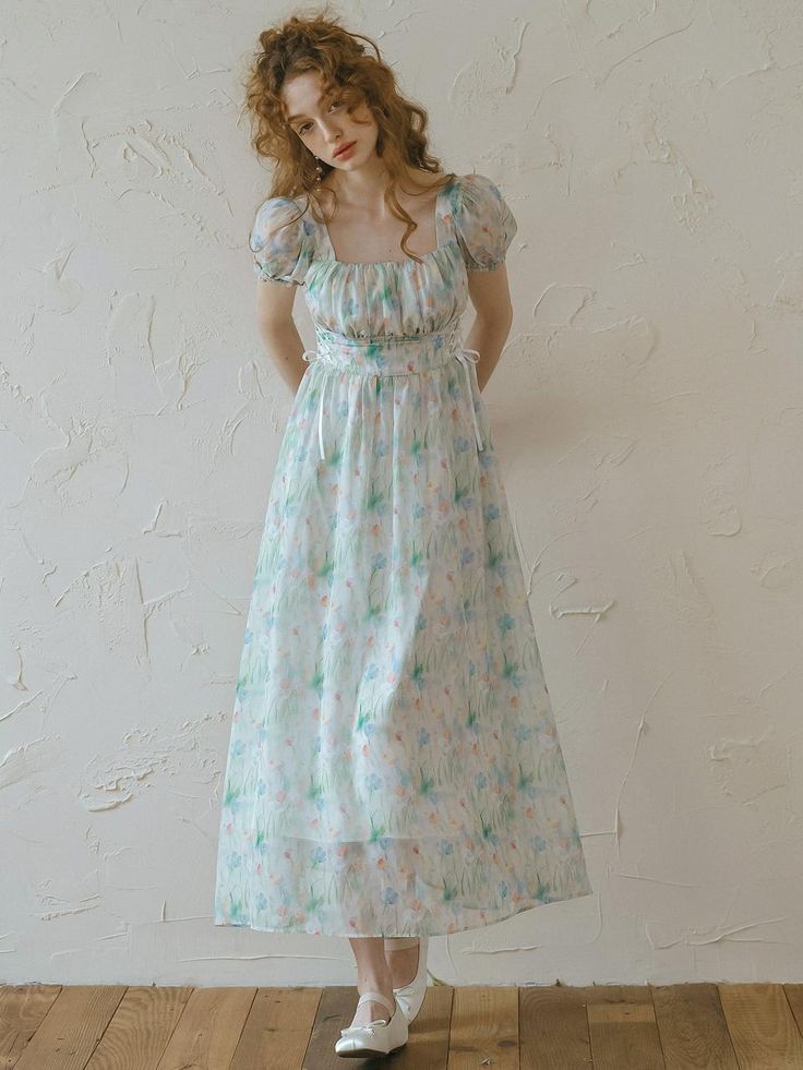 This product is a Forest Print Waist Strap Dress that captures the essence of a whimsical woodland scene with its delicate print. The dress features a soft, flowing chiffon fabric that gracefully drapes over the body, accentuated by a waist strap that enhances the silhouette. It's adorned with puff sleeves and a square neckline, adding a touch of romance and vintage charm. - This dress is elegantly designed with a forest-inspired print, making it ideal for those who appreciate nature-themed Sheer Ethereal Spring Dresses, Ethereal Sheer Dresses For Spring, Spring Ethereal Dress, Ethereal Spring Dresses, Dreamy Summer Dress For Garden Party, Dreamy Fitted Spring Dress, Dreamy Dress For Summer Garden Party, Dreamy Dresses For Summer Garden Party, Green Floral Print Chiffon Dress For Garden Party