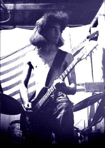 a black and white photo of a man playing an electric guitar