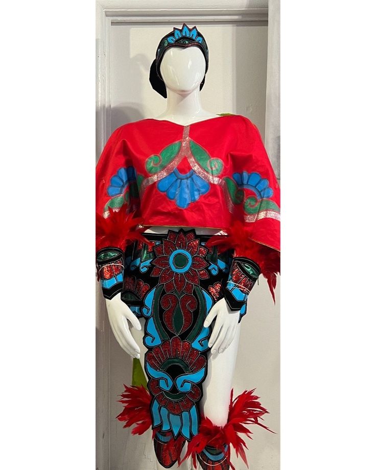 a mannequin wearing a red dress with blue and green designs on it's chest