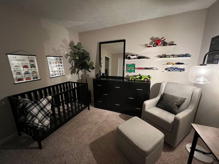 a baby's room with a black crib, white chair and gray ottoman