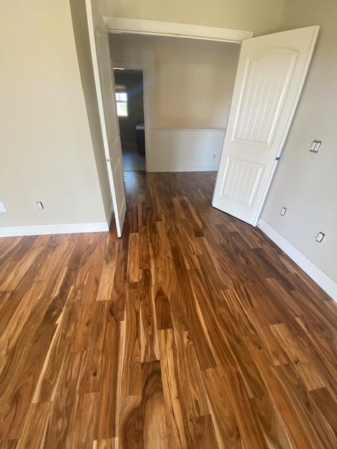 an empty room with hard wood floors and white doors