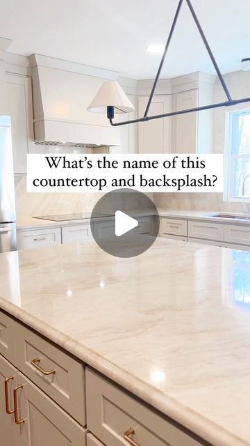 a large kitchen with white cabinets and marble counter tops that says, what's the name of this countertop and backsplash?