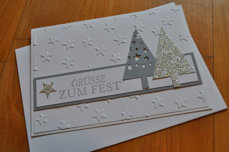 a close up of a greeting card on a wooden surface with stars and trees in the background