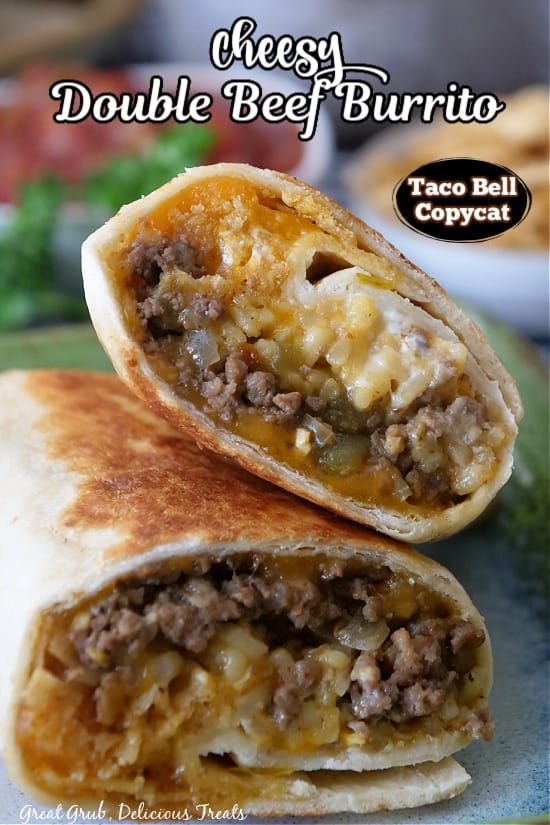 two burritos cut in half sitting on top of a plate with meat and cheese