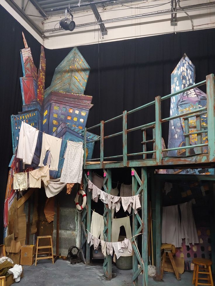 the stage is set up for an upcoming play with clothes hanging out to dry in front of it