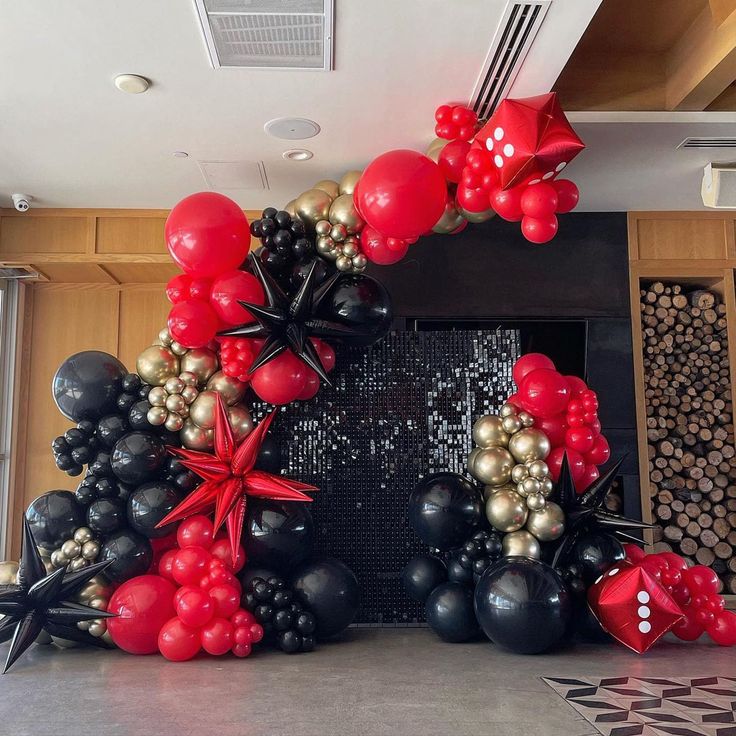 a balloon arch with red, black and gold balloons in the shape of a star