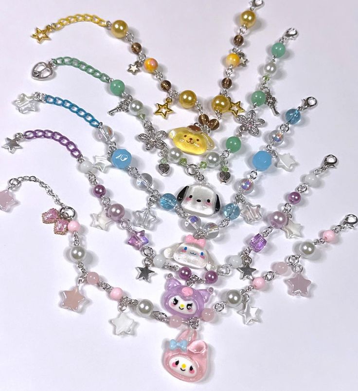 a bunch of necklaces that are on a white surface with beads and charms around them