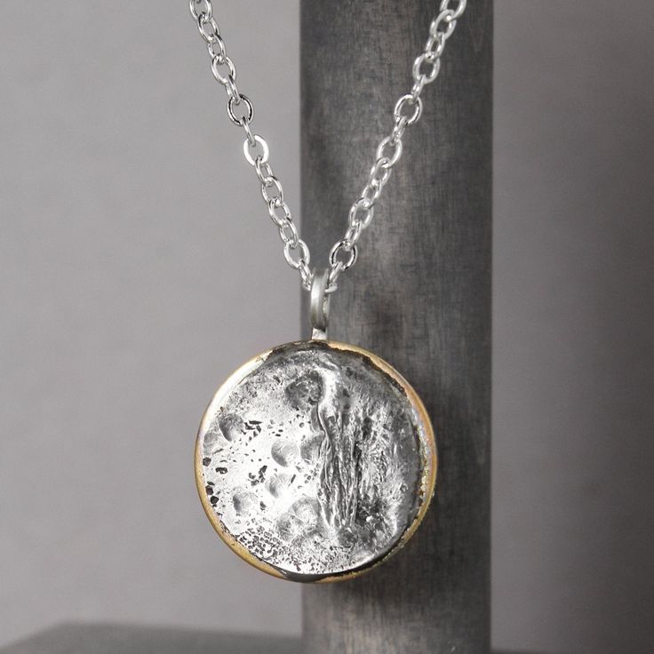 In 2017, the solar eclipse's path of totality found its way to Casper, Wyoming and sparked pure magic. Our Solar Eclipse Necklace is meant to do just that. Inspired by the celestial spectacle, we hope this handmade piece reminds you to look up and see the world through new eyes from time to time. Handcrafted with love in the heart of Wyoming. Necklace Details Pewter & Brass Charm on a dainty bail Sterling silver chain - choose your length Includes jewelry care card & polishing pad Free standard Artisan Silver Necklace With Moon Phase, Artisan Silver Necklace With Moon Phase Detail, Celestial Necklace With Large Round Pendant, Celestial Style Necklace With Large Round Pendant, Artisan Moon Charm Necklaces, Unique Silver Moon Phase Necklace, Unique Silver Necklace With Moon Phase Detail, Celestial Hand Forged Necklace Gift, Artisan Moon Phase Jewelry Gift