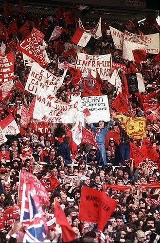 a large group of people holding up red and white signs in front of a crowd