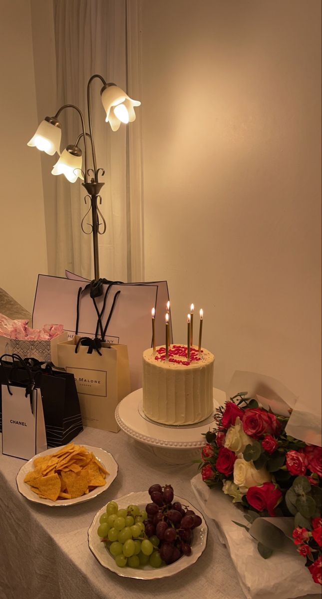 a table topped with two cakes covered in frosting and surrounded by other food items