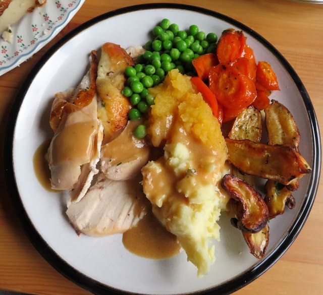 a white plate topped with meat and veggies on top of a wooden table