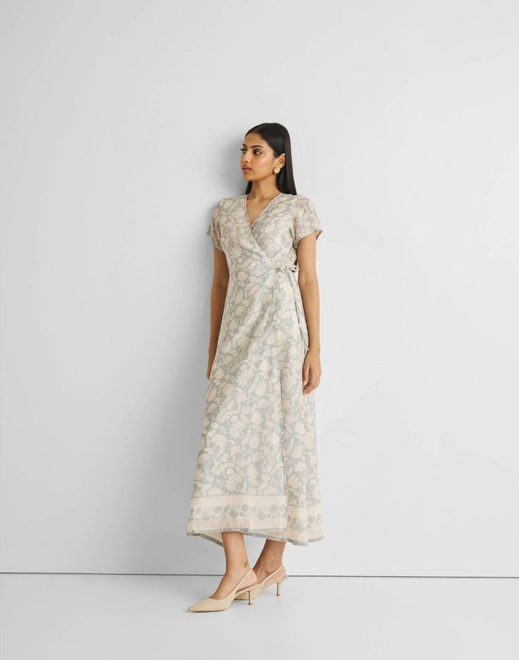 Unveil elegance with our 'Maxi Wrap Dress in Blue Florals,' featuring a relaxed fit and adorned with delicate blooms. This chic wrap dress, perfect for cool evenings or leisurely afternoons, offers both style and comfort. Embrace its versatile design, complemented by the convenience of pockets on both sides. Elevate your summer wardrobe with this trendy maxi dress, ideal for casual gatherings or a stylish day out. Wash in cold water or dry clean only Do not soak bleach or wring Line dry in shade Spring Silk Wrap Dress, Maxi Length, Feminine Floral Print V-neck Wrap Dress, Spring Silk Wrap Maxi Dress, Elegant Floral Print Maxi Wrap Dress, Silk Wrap Maxi Dress For Spring, Elegant Floral Print Wrap Maxi Dress, Spring Garden Party Wrap Dress, Summer Silk Wrap Dress, Elegant Floral Print Wrap Dress For Summer