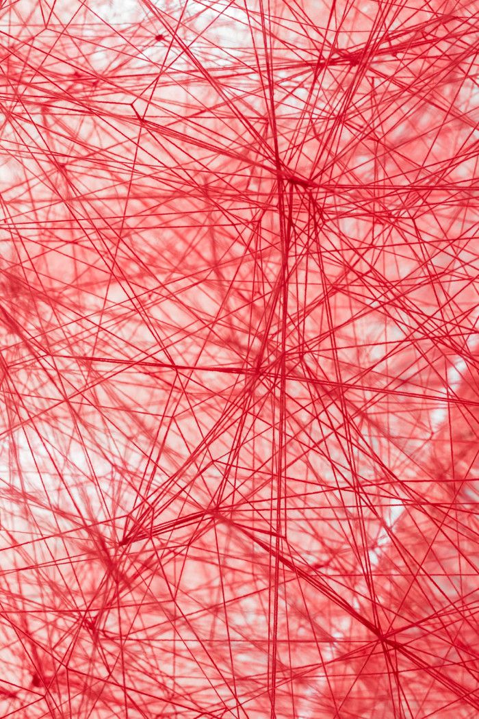 an abstract red background consisting of lines and shapes that appear to be woven into each other