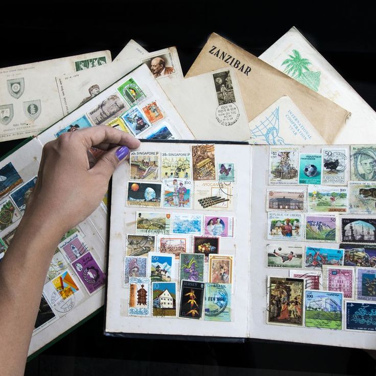 a person holding an open book filled with stamps