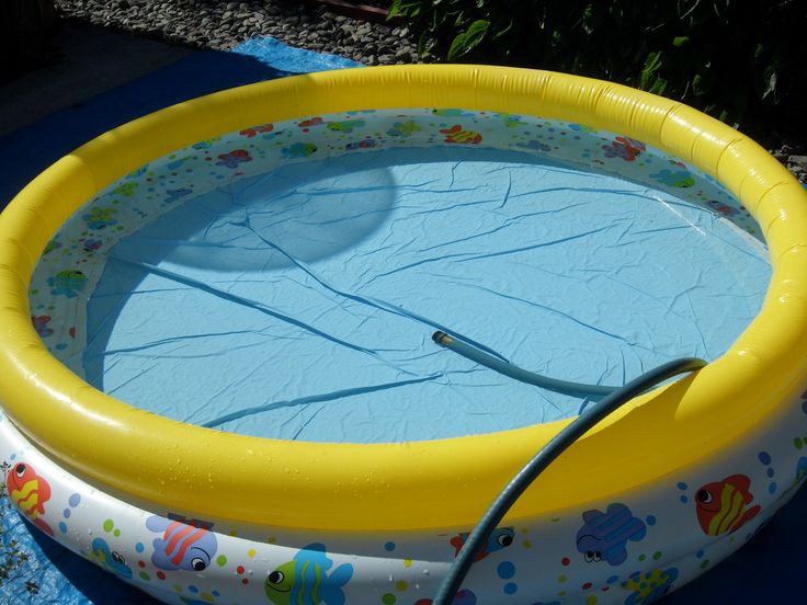 an inflatable swimming pool with a hose attached to the side and water sprinkles on it