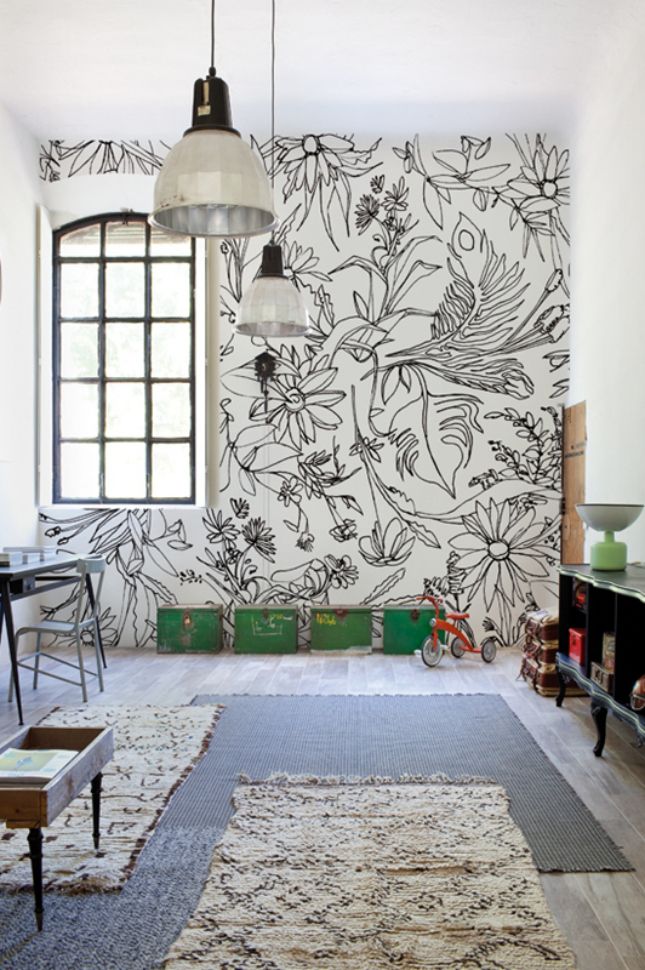 a living room with floral wallpaper and rugs