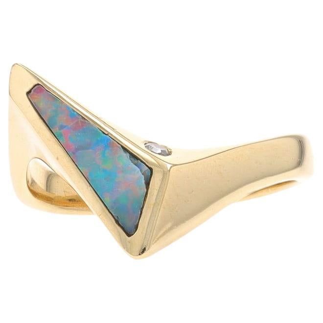 Size: 6 Metal Content: 14k Yellow Gold Stone Information Natural Opal Cut: Inlay Natural Diamond Carat(s): .03ct Cut: Single Color: H Clarity: VS1 Style: Solitaire with Accent Bypass Theme: Geometric Measurements Face Height (north to south): 9/16" (13.6mm) Rise Above Finger: 3/16" (4mm) Weight: 4.1 Grams Stamps: 14k Condition: Pre-Owned Condition Note: The opal is chipped from previous wear. Professionally cleaned, polished, and tested to guarantee metal content. Luxury Unique Rings With Inlay, Modern 14k Gold Opal Ring With Polished Finish, Modern Opal Ring In 14k Gold With Polished Finish, Modern 14k Gold Opal Ring For Formal Occasions, Modern 14k Gold Opal Ring For Formal Events, Modern 14k Gold Opal Gemstone Ring, Opal Diamond Ring, Bypass Ring, Synthetic Opal