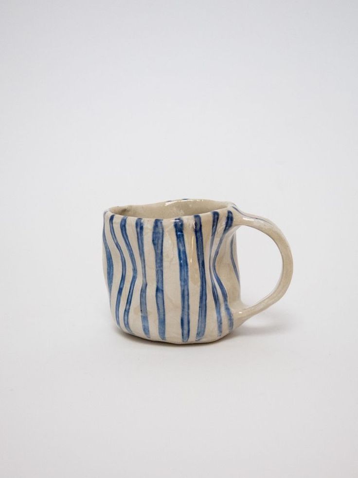 a blue and white striped mug sitting on top of a table